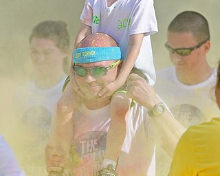 YOUNGSTOWN, OHIO - JUNE 11, 2016: Nick McDonald 6, rides on the shoulders of Shane Sistrunk as the two get sprayed with color powder as they run down West Front Street during the Color Run, Saturday morning. DAVID DERMER | THE VINDICATOR