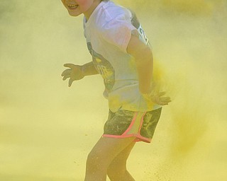 YOUNGSTOWN, OHIO - JUNE 11, 2016: Adalee Grubbs 6, of Leetonia runs through a cloud of yellow powder while running down West Front Street during the Color Run, Saturday morning. DAVID DERMER | THE VINDICATOR