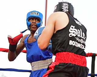 AUSTIN TOWN, OHIO - JUNE 11, 2016: Isaac Chatman of Youngstown (blue) winds up to throw a punch at Drew Smith of Salem (black) during a amateur boxing bout Saturday night at the Hollywood Palms Hotel. DAVID DERMER | THE VINDICATOR