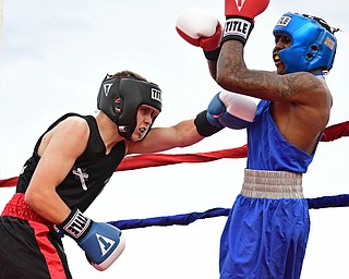 AUSTIN TOWN, OHIO - JUNE 11, 2016: Drew Smith of Salem (left) throws a punch to the body of Isaac Chatman of Youngstown (right) during a amateur boxing bout Saturday night at the Hollywood Palms Hotel. DAVID DERMER | THE VINDICATOR