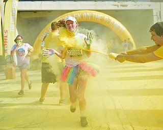 YOUNGSTOWN, OHIO - JUNE 11, 2016: Elizabeth Panic of Mineral Ridge runs while being blasted with yellow powder on West Front Street during the Color Run, Saturday morning. DAVID DERMER | THE VINDICATOR