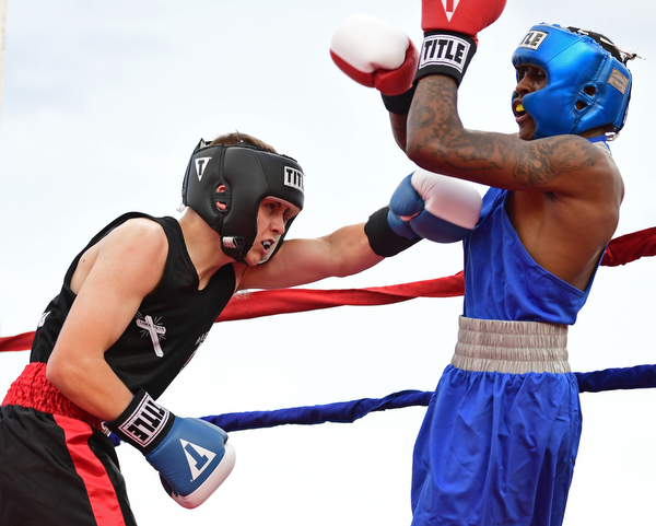 AUSTINTOWN, OHIO - JUNE 11, 2016: Drew Smith of Salem (left) throws a punch to the body of Isaac Chatman of Youngstown (right) during the Fighting for Hope amateur boxing show, Saturday night at the California Palms Hotel. DAVID DERMER | THE VINDICATOR