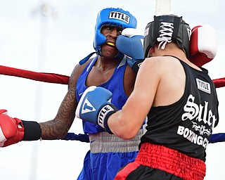 AUSTINTOWN, OHIO - JUNE 11, 2016: Isaac Chatman of Youngstown (blue) is punched in the head by Drew Smith of Salem (black) while winding up to throw a punch during the Fighting for Hope amateur boxing show Saturday night at the California Palms Hotel. DAVID DERMER | THE VINDICATOR