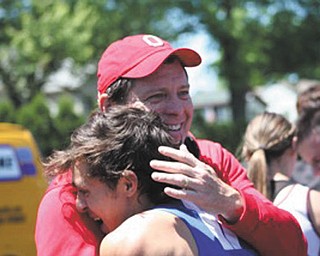 Richard Partika with the red hat and Bryan Partika in the track jersey are both from Poland. The photo was taken in May 2015 after the Division II District Track meet at Salem High School. Richard is hugging his son after he won the District title in the 300 meter hurdles and broke the Poland HS record in the event. The photo was taken by Monique Malmer.
