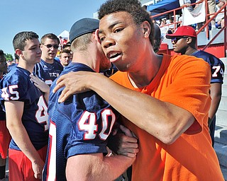 Jeff Lange | The Vindicator  SAT, JUN 18, 2016 - Dante Boley of Columbiana (facing) hugs Fitch Falcon football alum Matt Argiro (40) prior to the start of Saturday's Special Olympics event at Austintown Fitch High School.