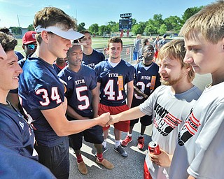 Jeff Lange | The Vindicator  SAT, JUN 18, 2016 - Austintown Fitch's Bryce Warmouth (34) and other Falcon football players shake hands with Kent Roosevelt's Austin Starkey and Joe Davidson prior to the start of Saturday's Special Olympics event at Austintown Fitch High School.