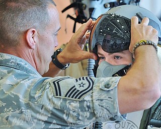 Jeff Lange | The Vindicator  SAT, JUN 18, 2016 - Dylan David of Youngstown (facing) tries on a flight helmet with assistance from Senior Master Sergeant Jim Haupt, Super Intendant of Air Crew Flight Equipment with the 910th's Operations Support Team, during an open house at the Youngstown Air Reserve Station in Vienna on Saturday.