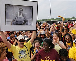 A man holds up a photo of a young LeBron James while waiting for the NBA basketball Champion Cleveland Cavaliers to arrive in Cleveland, Monday, June 20, 2016. (AP Photo/Tony Dejak)