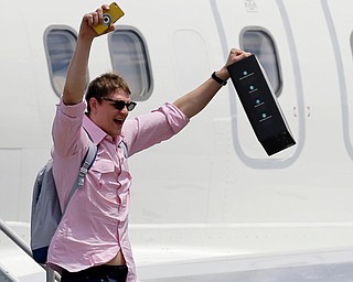 Cleveland Cavaliers' Timofey Mozgov, from Russia, raises his arms as he departs the airplane in Cleveland, Monday, June 20, 2016. The Cavaliers defeated Golden State in Game 7 of the NBA Finals on Sunday in Oakland, Calif. (AP Photo/Tony Dejak)