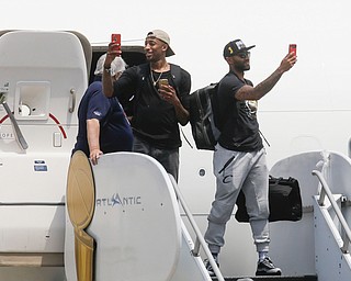 NBA champion Cleveland Cavaliers' Jordan McRae, right, and Iman Shumpert, left, take photos of a cheering crowd as they arrive at the airport Monday, June 20, 2016, in Cleveland. (AP Photo/John Minchillo)