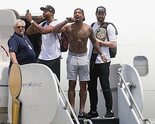 Cleveland Cavaliers' Tristan Thompson, second from left, J.R. Smith, center, and Kevin Love, right, celebrate as they arrive at the airport after winning Game 7 of basketball's NBA Finals against the Golden State Warriors the previous night, Monday, June 20, 2016, in Cleveland. Cleveland won 93-89. (AP Photo/John Minchillo)