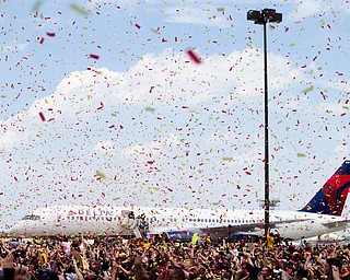 Confetti is sprayed over the crowd as the Cleveland Cavaliers arrive at the airport after winning Game 7 of basketball's NBA Finals against the Golden State Warriors the previous night, Monday, June 20, 2016, in Cleveland. Cleveland won 93-89. (AP Photo/John Minchillo)