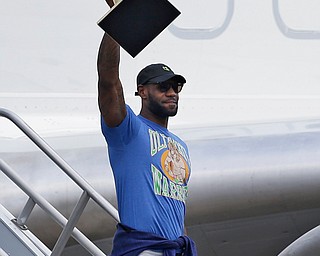 Cleveland Cavaliers' LeBron James raises the NBA Championship trophy after arriving at the airport, Monday, June 20, 2016, in Cleveland. (AP Photo/Tony Dejak)