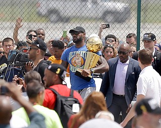 Cleveland Cavaliers' LeBron James carries the NBA Championship trophy after arriving in Cleveland, Monday, June 20, 2016. (AP Photo/Tony Dejak)