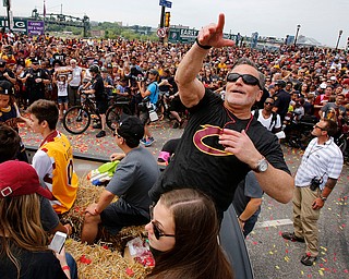 Cleveland Cavaliers owner Dan Gilbert tosses glass beads into the crowd during a parade celebrating the Cleveland Cavaliers' NBA Championship in downtown Cleveland Wednesday, June 22, 2016. (AP Photo/Gene J. Puskar)