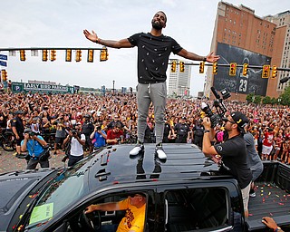 Cleveland Cavaliers' Kyrie Irving stands on the roof of a pickup truck to greet fans before the start of a parade celebrating the Cleveland Cavaliers' NBA Championship in downtown Cleveland Wednesday, June 22, 2016. (AP Photo/Gene J. Puskar)