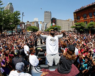 Cleveland Cavaliers' LeBron James, center, stands in the back of a Rolls Royce as it makes it way through the crowd lining the parade route in downtown Cleveland, Wedensday, June 22, 2016, celebrating the Cleveland Cavaliers' NBA Championship. (AP Photo/Gene J. Puskar)