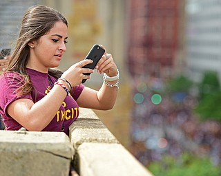 CLEVELAND, OHIO - JUNE 22, 2016: Marwa Manlouk of Cleveland, Ohio snaps a picture of the crowd on her cell phone from atop a parking deck on East 9th Street, Wednesday morning before the Cavaliers Championship Parade. DAVID DERMER | THE VINDICATOR