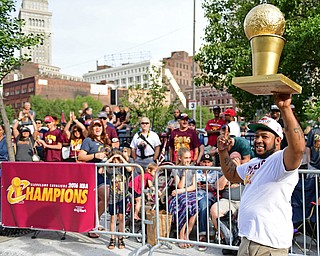 CLEVELAND, OHIO - JUNE 22, 2016: DeMilles Jones of Akron, Ohio walks down Huron Road in front of Quicken Loans Arena holding a home made NBA Championship Trophy Wednesday morning before the Cavaliers championship parade. DAVID DERMER | THE VINDICATOR