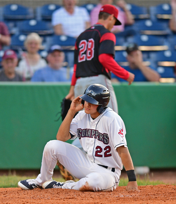 NILES, OHIO - JUNE 27, 2016: Luke Wakamatsu #22 of the Scrappers sits on the dirt after being tagged out at home plate during the fifth inning of Monday nights game at Eastwood Field. DAVID DERMER | THE VINDICATOR..Pitcher Reilly Hovis #28 of the Muckdogs pictured.