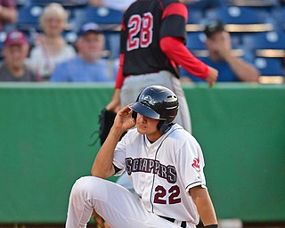 NILES, OHIO - JUNE 27, 2016: Luke Wakamatsu #22 of the Scrappers sits on the dirt after being tagged out at home plate during the fifth inning of Monday nights game at Eastwood Field. DAVID DERMER | THE VINDICATOR..Pitcher Reilly Hovis #28 of the Muckdogs pictured.
