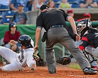 NILES, OHIO - JUNE 27, 2016: Luke Wakamatsu(22) of the Scrappers slides over home plate after being tagged out by catcher Pablo Garcia(7) of the Muckdogs during the fifth inning of Monday nights game at Eastwood Field. DAVID DERMER | THE VINDICATOR