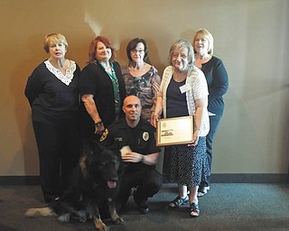 SPECIAL TO THE VINDICATOR
Above, in front, is Canfield Police Department K-9 officer Chad Debarr with Tron, and standing are Regina Jenkins, left, Jorine Stone, Luanna Jacobs, Bonnie Lambert who is presenting a plaque to the officer, and Amy Pendleton. Police dogs are trained to assist police and law-enforcement personnel in finding suspects through smell, protecting its handler, finding hidden objects, knowing how to respond when under fire and detecting explosives and narcotics. Nine-year-old Tron will retire in March 2017 due to physical problems. He served seven years. A new dog will be purchased in April and training costs approximately $14,000. The Newcomers donated to the fund and Debarr thanked the club for its support. To contribute to the Canfield Police Canine Fund, call the department at 330-533-4903. Newcomers is a social club to help those who are new to the community to make new friends. They participate in community activities and raise funds to help non-profit organizations.