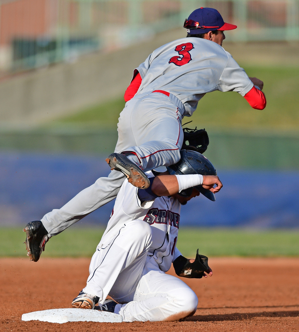 Paul Gonzalez(16) of the Scrappers takes a knee to the head from Clayton Brandt(3) of the Doubledays while he flies though the air. The injury on the play would knock Gonzalez out of the game.  DAVID DERMER | THE VINDICATOR.