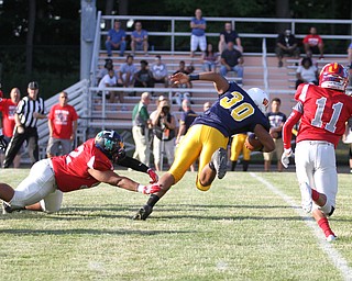 Nikos Frazier | The Vindicator..Pennsylvania's Thomas Dean(30) is taken down by Ohio's Michael Page(52) in the first quarter of the 2016 Battle of the Border at Springfield High School in New Middleton.