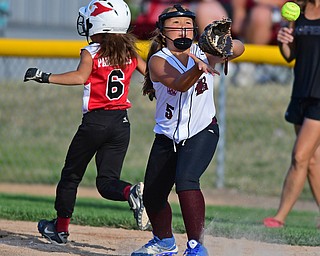 BOARDMAN, OHIO - JUNE 30, 2016: First baseman Gabriella Bagdassarian(5) of Boardman looks at incoming ball as Gianna Pannunzio(6) of Canfield gets the single in the fifth inning of their District 2 softball championship game at the Field of Dreams. DAVID DERMER | THE VINDICATOR