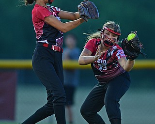 BOARDMAN, OHIO - JUNE 30, 2016: Short stop Mia Opalick(13) of Canfield hangs on to the ball after colliding with third baseman Emma Castronova(23) after they both went after the ball fourth inning of their District 2 softball championship game at the Field of Dreams. DAVID DERMER | THE VINDICATOR