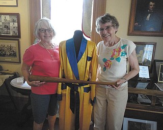 SPECIAL TO THE VINDICATOR
The summer theme for Girard Historical Society’s open houses is Sports through the Ages. Sally Curl, left, and Carley O’Neill display a boxer’s robe and baseball bat which are part of the summer display at the Barnhisel House, 1011 N. State St., Girard. Hall of Famers from Girard are included in the display that dates from 1913. Fred Faiver, Tony Maiorana, Pat Meyer, Mel and Bill Triplett are a few of the athletes recognized. Girls basketball, archery and early uniforms also are on display. Open house hours are 2 to 4 p.m. the second and fourth Sunday of each month. For information call the society at 330-545-4899.