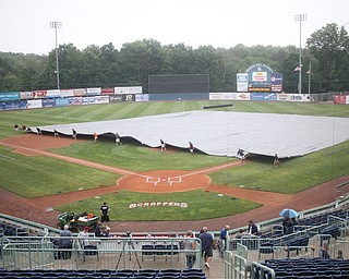 Nikos Frazier | The Vindicator..Eastwood Field grounds crew covers the diamond with a tarp on July 4, 2016 before the Scrappers took on the Lake Monsters.