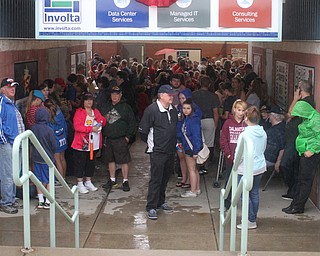 Nikos Frazier | The Vindicator..Fans take refuge in a breezeway during a short rain delay on July 4, 2016.