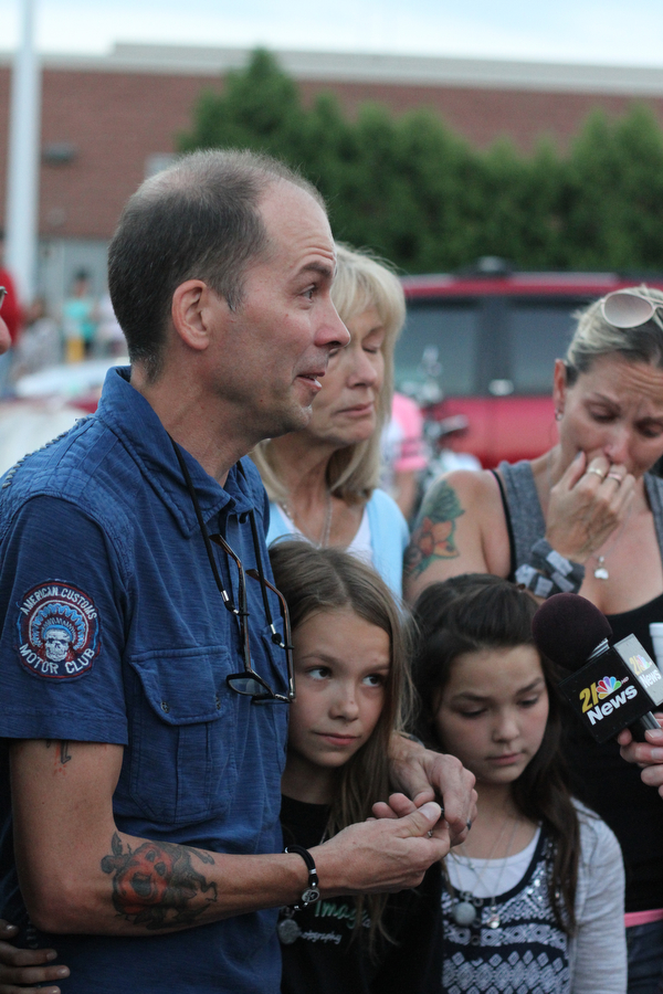 Nikos Frazier | The Vindicator..Jimmy Taafe, left,  puts his arm his daughters Mickayla(center) and Gianna at a candlelight vigil for his late wife, Kristy Wolfe Taafe, who died unexpectedly Sunday.