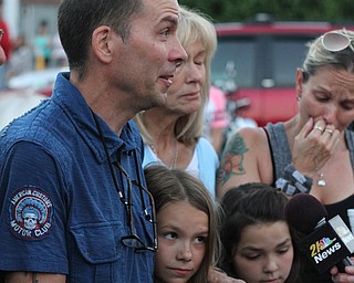 Nikos Frazier | The Vindicator..Jimmy Taafe, left,  puts his arm his daughters Mickayla(center) and Gianna at a candlelight vigil for his late wife, Kristy Wolfe Taafe, who died unexpectedly Sunday.