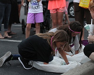 Nikos Frazier | The Vindicator..Mickayla(left) Gianna(right) Taafe write messages on Chinese lanterns for their late mother, Kristy Wolfe Taafe at a candlelight vigil at Struthers Elementary School.