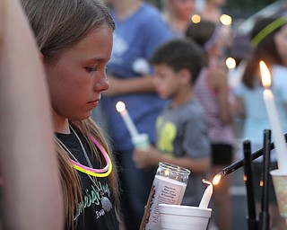 Nikos Frazier | The Vindicator..Mickayla Taafe, 10, watches as a candle is light at a candlelight vigil for her mother, Kristy Wolfe Taafe, who died unexpectedly Sunday.