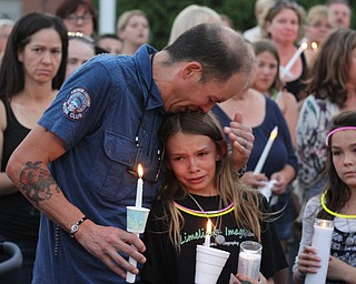 Nikos Frazier | The Vindicator..Jimmy Taafe(left) comforts his daughters, Mickayla(center), 10 and Gianna(right), 9, at a candlelight vigil for his late wife, Kristy Wolfe Taafe, who died unexpectedly Sunday.