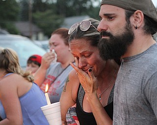 Nikos Frazier | The Vindicator..Kelly Procaccini(left) is comforted by her husband Tony Procaccini at a vigil for her late sister, Kristy Wolfe Taafe, who died unexpectedly Sunday.