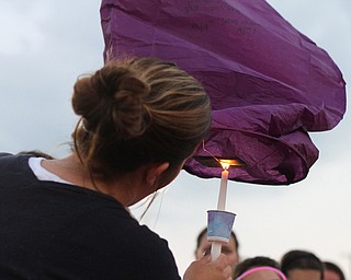 Nikos Frazier | The Vindicator..A woman lights a Chinese lantern at the candlelight vigil for the late Kristy Wolfe Taafe.