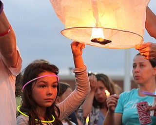 Nikos Frazier | The Vindicator..Gianna Taafe, 9, holds part of a chinese lantern at a candlelight vigil for her mother, Kristy Wolfe Taafe, who died unexpectedly on Sunday.