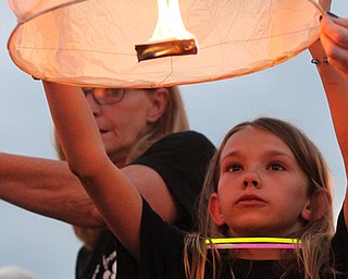 Nikos Frazier | The Vindicator..MicKayla Taafe, 10, holds a chinese lantern at a candlelight vigil for her mother, Kristy Wolfe Taafe, who died unexpectedly on Sunday.