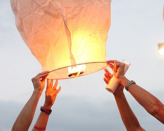 Nikos Frazier | The Vindicator..A Chinese lantern with messages for Kristy Wolfe Taafe is held by two women. Taafe died unexpectedly on Sunday.