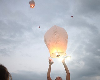 Nikos Frazier | The Vindicator..A woman releases a chinese lantern for Kristy Wolfe Taafe who died unexpectedly on Sunday.