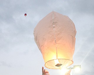 Nikos Frazier | The Vindicator..A woman releases a chinese lantern for Kristy Wolfe Taafe who died unexpectedly on Sunday.
