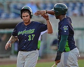 NILES, OHIO - JULY 5, 2016: Base runner Johnny Rodriguez #17 of the Lake Monsters is congratulated by teammate Miguel Mercedes #7 after the pair scored on a RBI single by Sean Murphy #33 in the sixth inning of Tuesday nights game at Eastwood Field. DAVID DERMER | THE VINDICATOR
