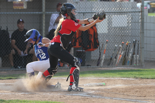 Nikos Frazier | The Vindicator..Poland's Camryn Latttanzio(12) slides into home in the Junior League district title game at the Field of Dreams in Boardman.