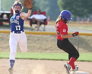Nikos Frazier | The Vindicator..Poland Shortstop, Lauren Sienkiewicz(17) jumps into the air to catch the ball as Canfield runner, Mary Gomez lands on second in the Junior League district title game at the Field of Dreams in Boardman.