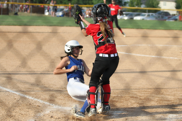 Nikos Frazier | The Vindicator.. Poland runner, Hannah Wolfe(5) slides into home as Canfield Catcher, Jenna Troxil(22) catches the ball to late in the Junior League district title game at the Field of Dreams in Boardman.